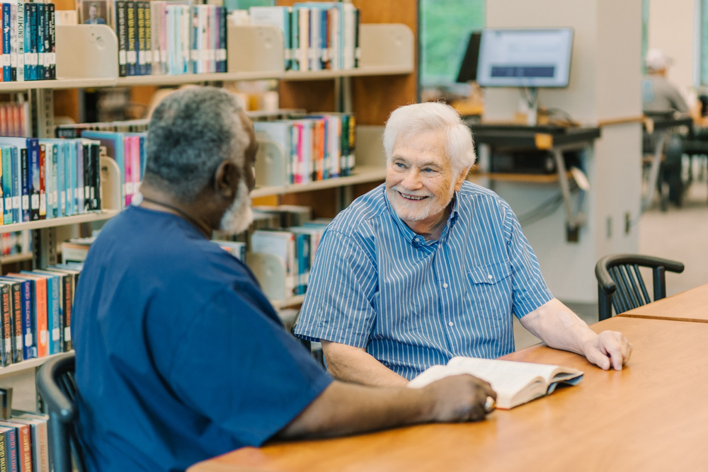 DayBreak caregiver talking with an older adult client at a library
